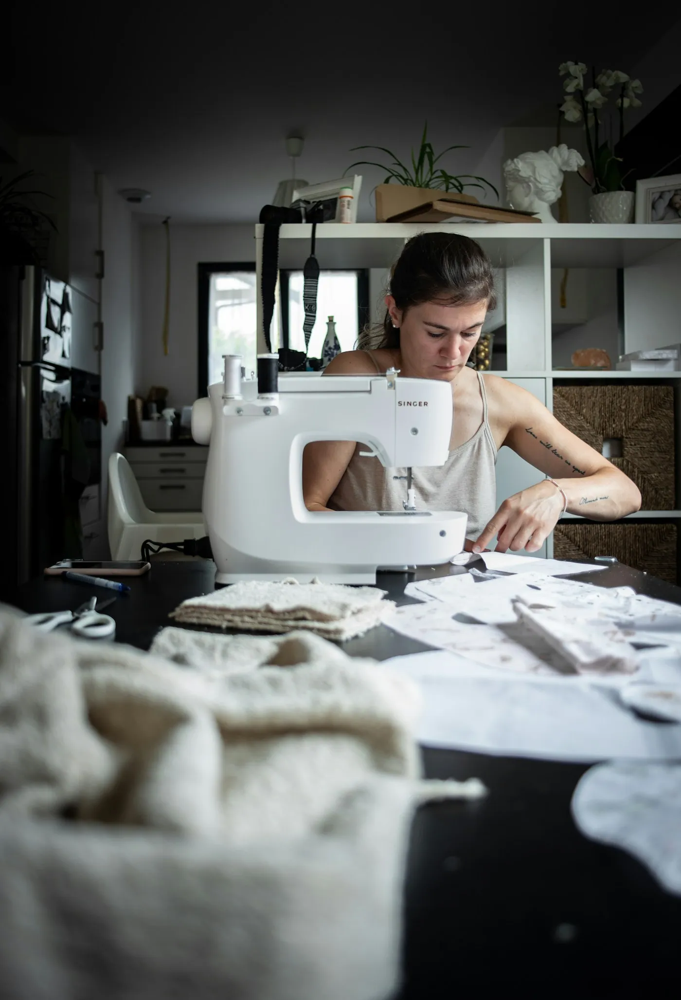 Sewing at the machine in a bright workroom