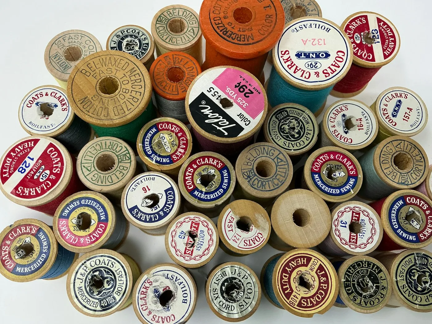 A jumble of vintage wooden thread spools
